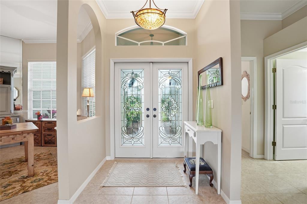 An entryway features double glass-paneled doors, a light fixture, and a white console table — 12761 DRESDEN COURT, FORT MYERS, FL