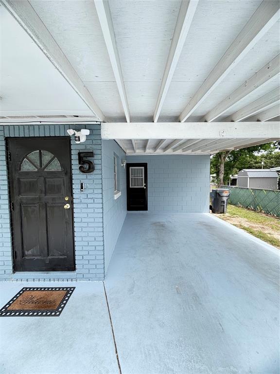 A light blue painted exterior features a covered carport, a front door, and a side entrance — 5 MOONLIGHT LANE, WINTER HAVEN, FL