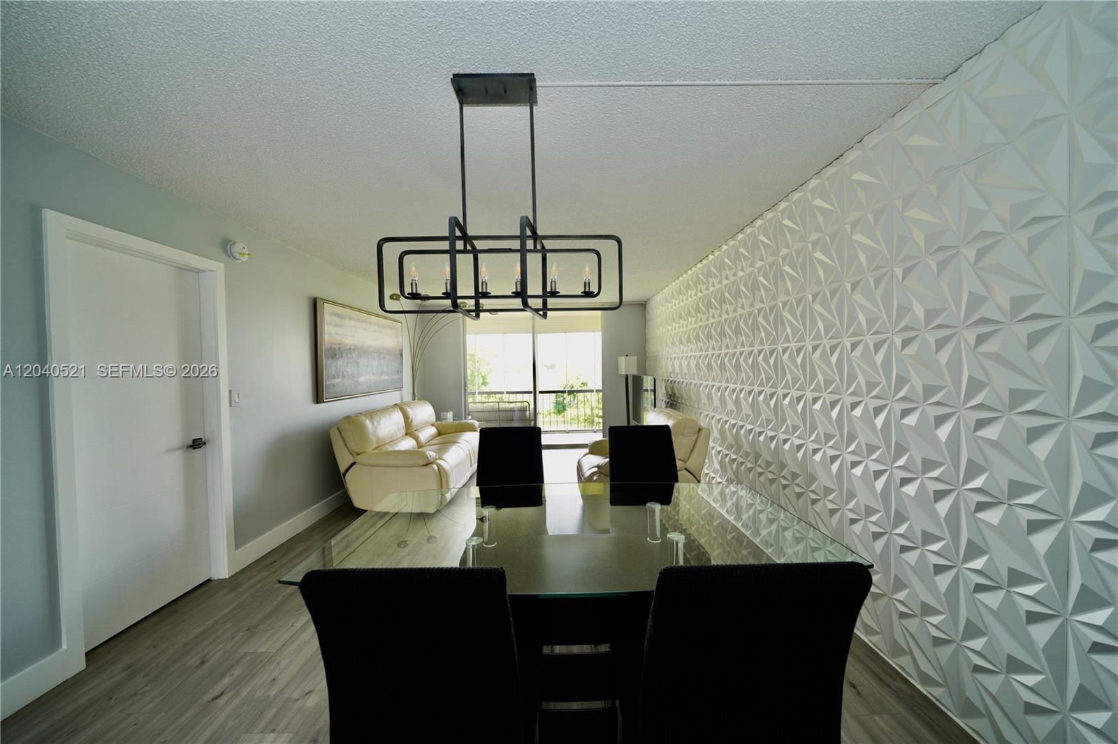 A dining area features a glass table, black chairs, and a textured white accent wall — 2541 Aragon Blvd # 305, Sunrise FL 33322, SUNRISE, FL