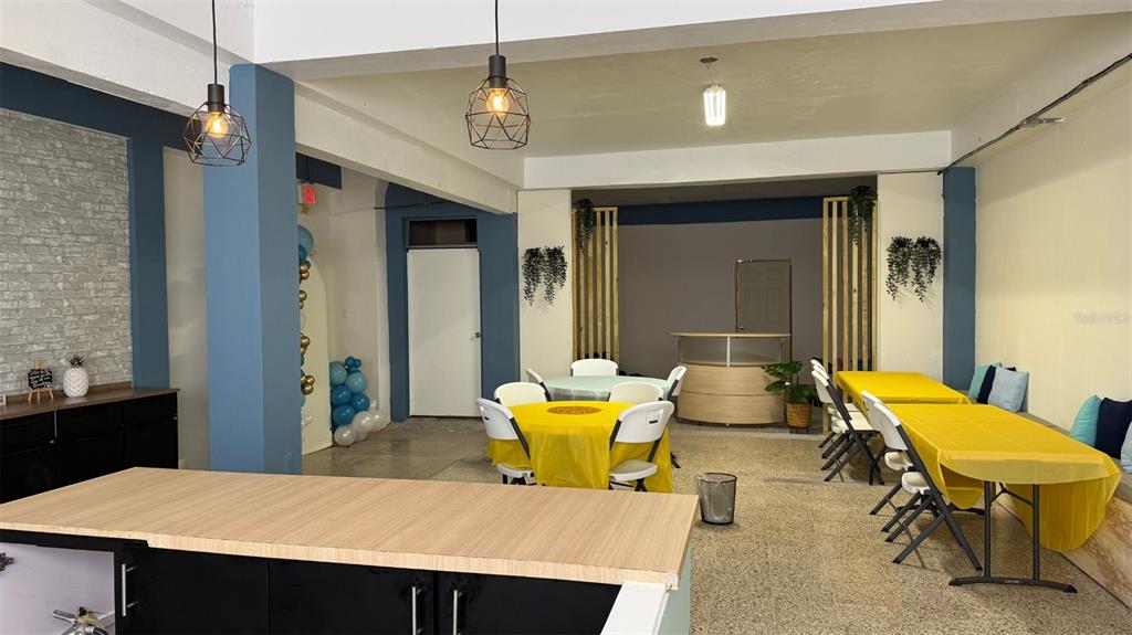 A room with yellow-covered tables, chairs, pendant lights, and a brick-patterned accent wall — #6 CALLE HERMINO DIAZ NAVARRO, GUAYNABO, PR