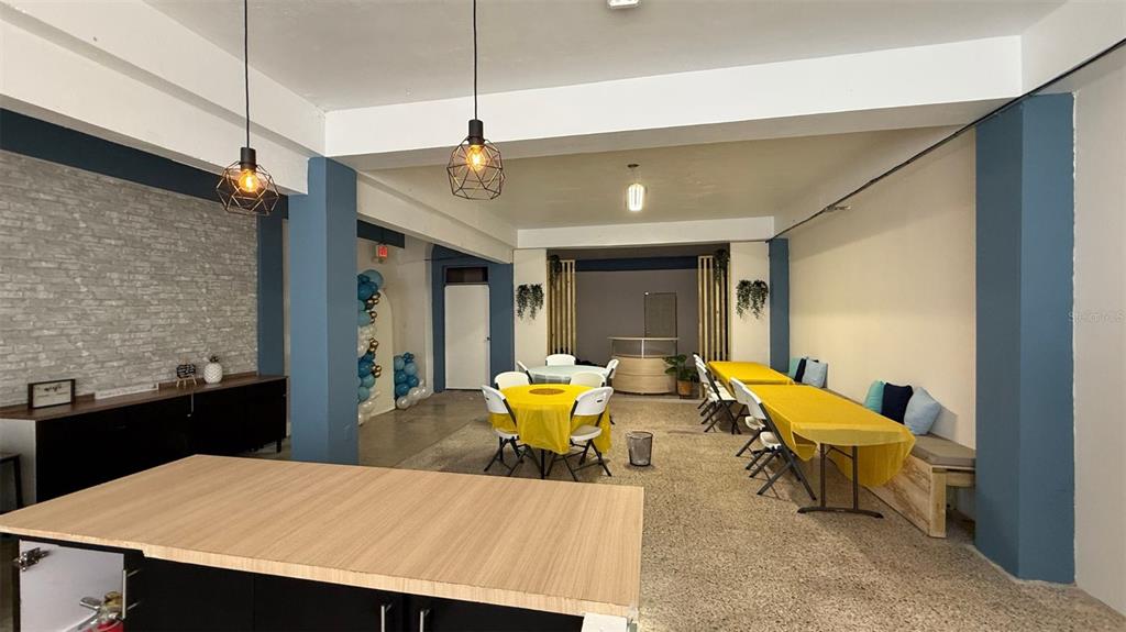 An open-plan event space features yellow-clothed tables, blue accent walls, and a wood-topped island — #6 CALLE HERMINO DIAZ NAVARRO, GUAYNABO, PR