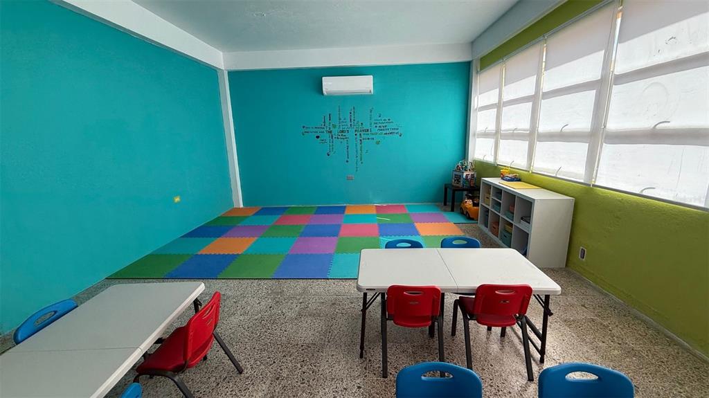 A classroom with a colorful foam floor mat, white tables, red chairs, and large windows — #6 CALLE HERMINO DIAZ NAVARRO, GUAYNABO, PR