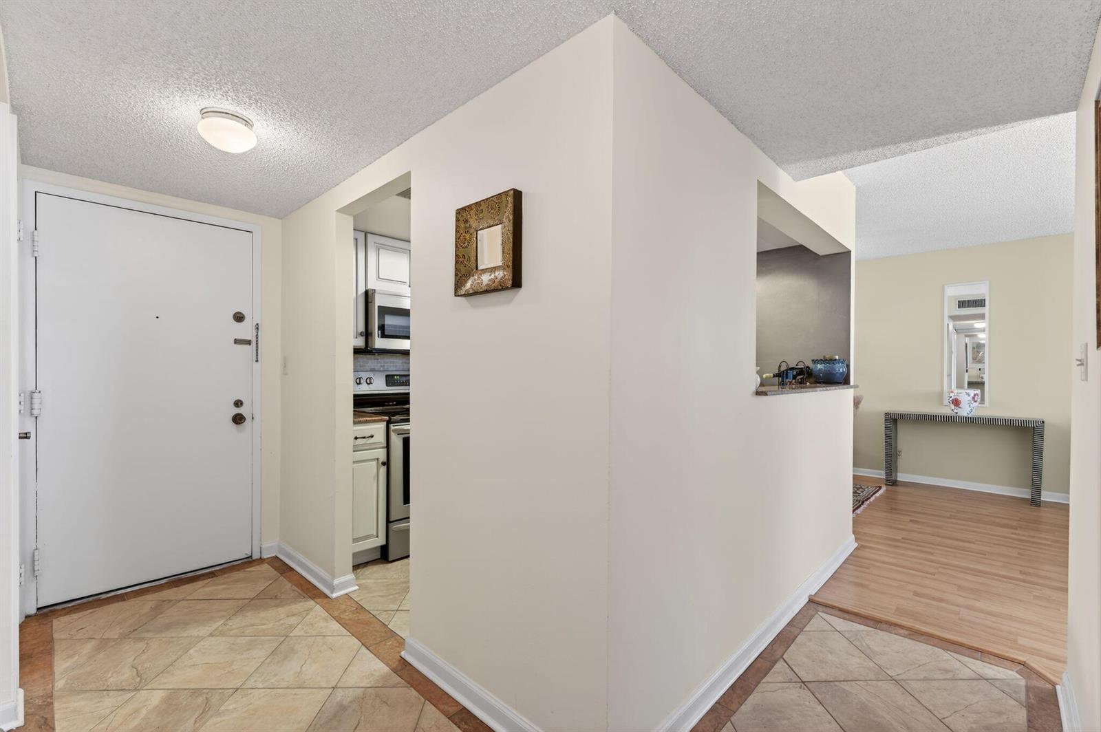 An entryway with tile flooring leads to a kitchen and a living area with wood floors — 1009 N Ocean Boulevard # 312, Pompano Beach FL 33062, POMPANO BEACH, FL