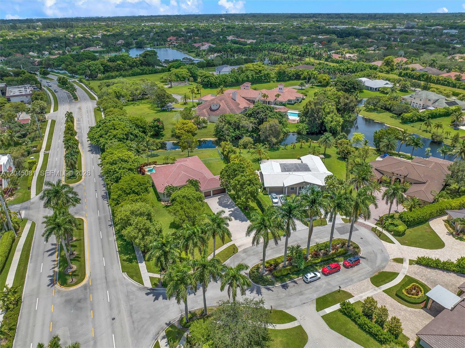 An aerial view shows several houses with pools and palm trees near a winding road — 16310 Paddock Ln, Weston FL 33326, WESTON, FL