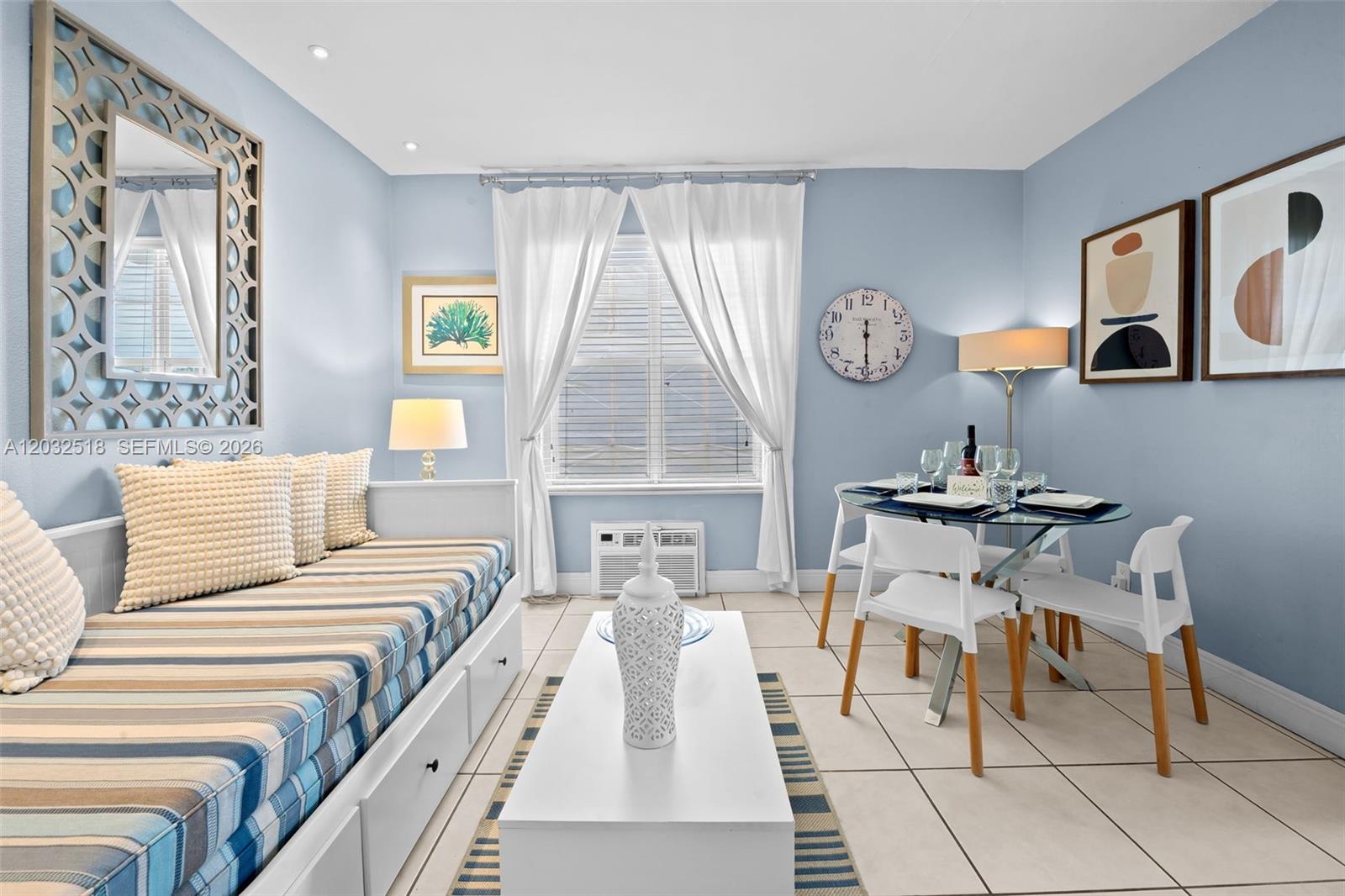 A light blue room features a daybed, a glass dining table, and a wall clock — 3030 Collins Ave # 4E, Miami Beach FL 33140, MIAMI BEACH, FL