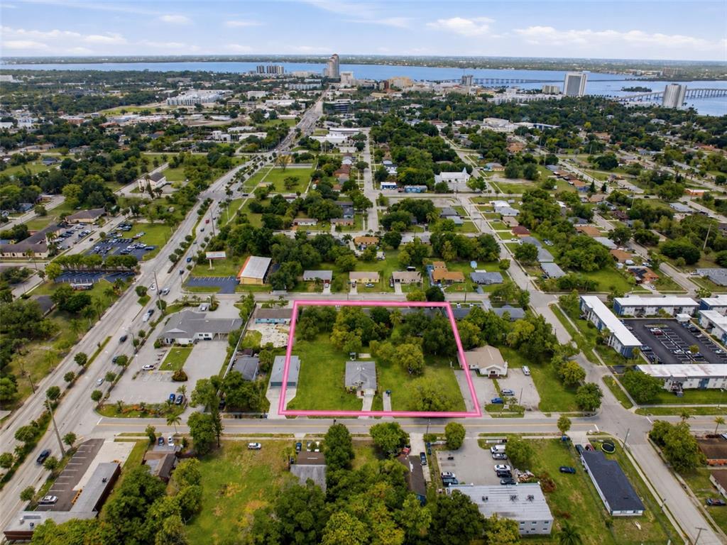 An aerial view shows a rectangular lot outlined in pink containing a house and trees — 1938 LILLIE STREET, FORT MYERS, FL