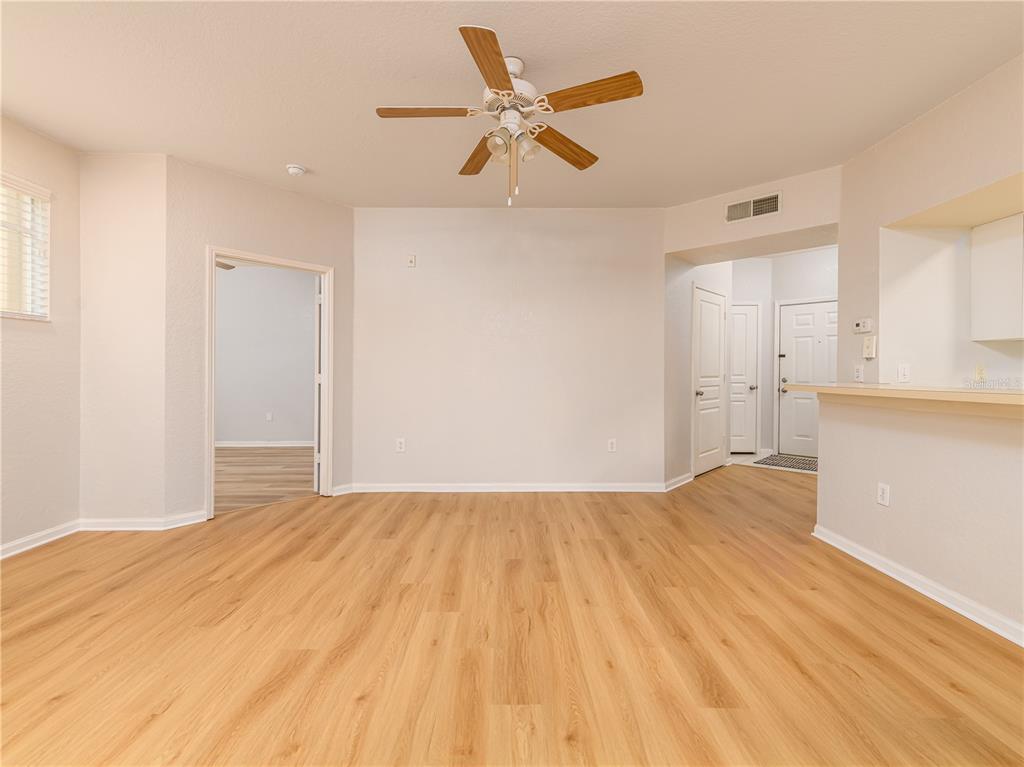 An empty room features light wood-look flooring, white walls, and a ceiling fan — 5125 PALM SPRINGS BOULEVARD UNIT 2206, TAMPA, FL