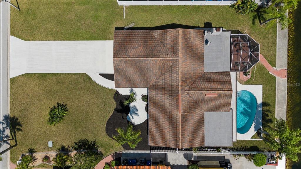 An aerial view of a house with a tiled roof, swimming pool, and screened lanai — 3340 FLORAMAR TERRACE, NEW PORT RICHEY, FL