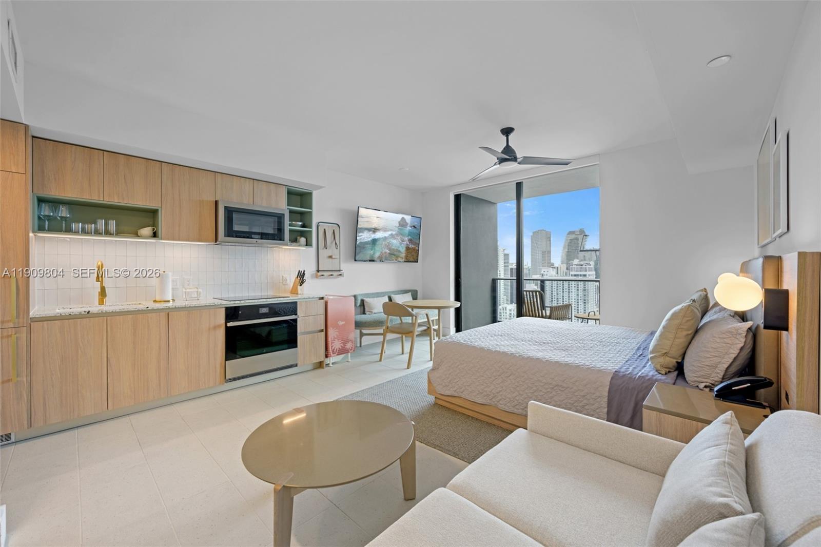 A studio apartment features a kitchenette, a bed, a seating area, and a balcony view — 159 NE 6th St # 3706, Miami FL 33132, MIAMI, FL
