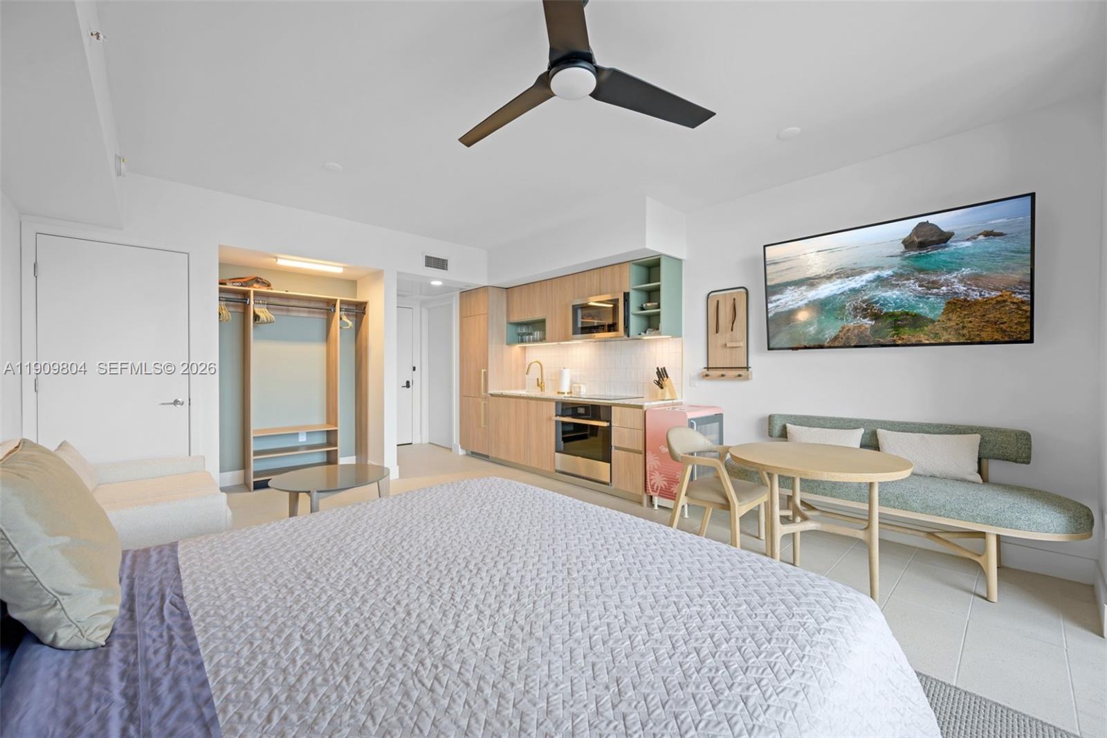 A studio apartment features a kitchenette, a bed, a dining area, and a wall-mounted television — 159 NE 6th St # 3706, Miami FL 33132, MIAMI, FL