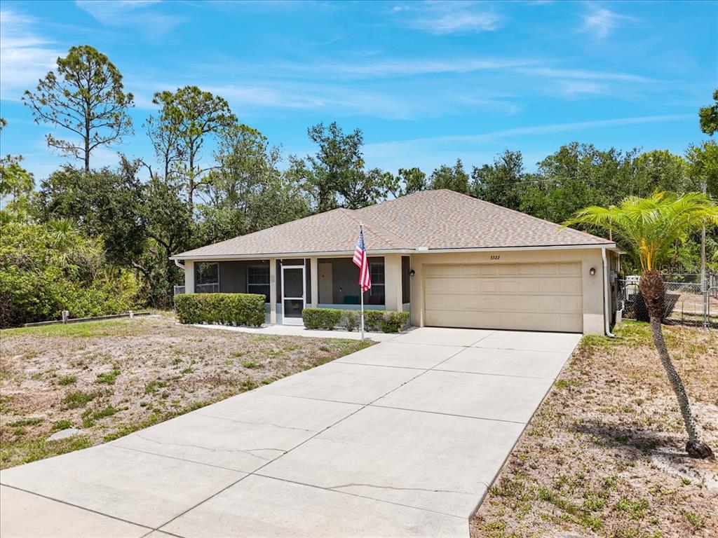 A single-story house with a beige exterior, a two-car garage, and a concrete driveway — 3322 HAMPTON STREET, PORT CHARLOTTE, FL