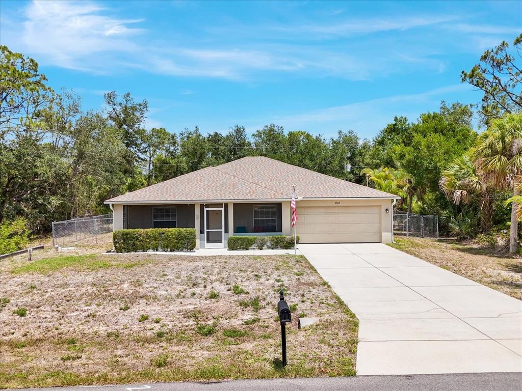 A single-story house with a beige garage and a concrete driveway sits on a lot — 3322 HAMPTON STREET, PORT CHARLOTTE, FL