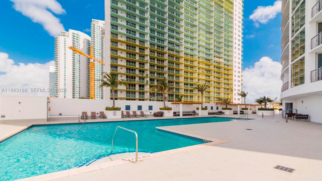 A swimming pool sits on a patio in front of a tall residential building — 1750 N Bayshore Dr # 1104, Miami FL 33132, MIAMI, FL