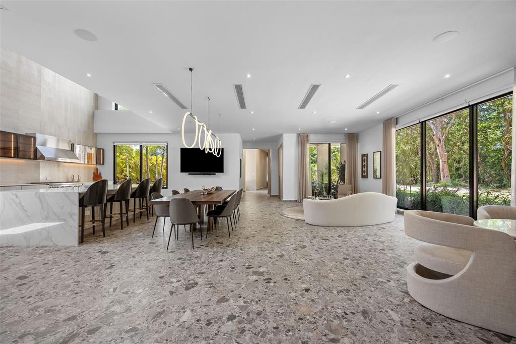 An open-concept living and dining area features terrazzo flooring, a marble kitchen island, and windows — 904 VILLA DORADO ESTATES, DORADO, PR