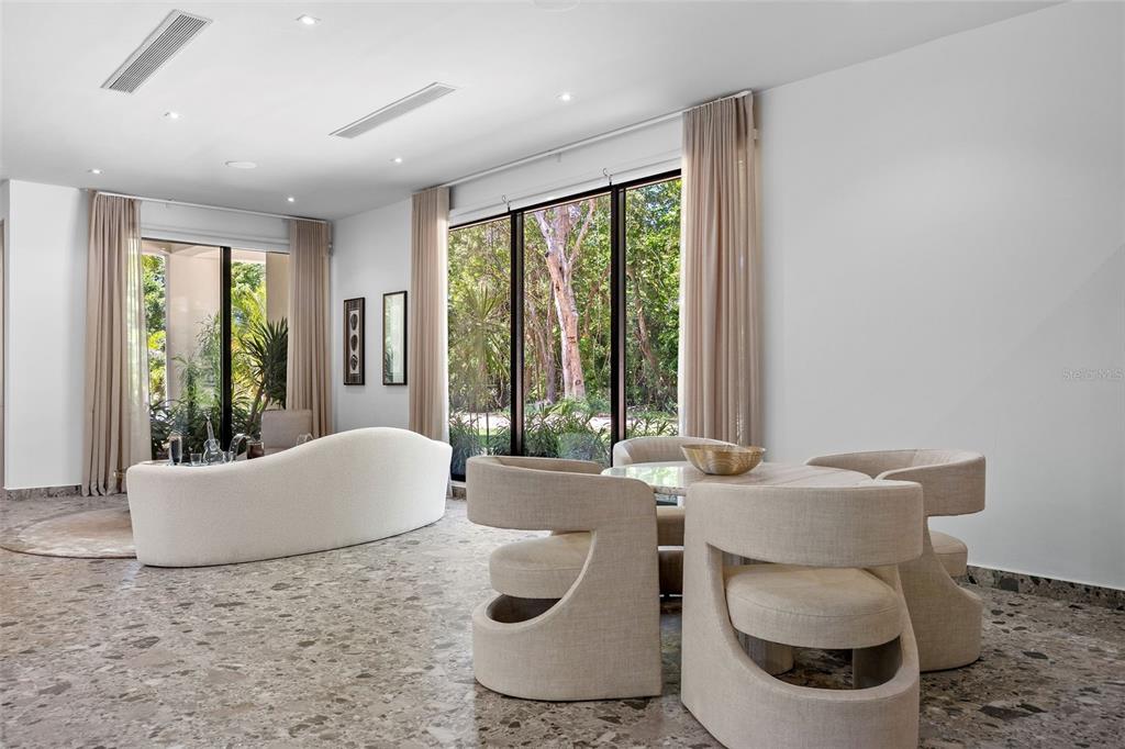 A modern living and dining area features terrazzo floors, floor-to-ceiling windows, and neutral furniture — 904 VILLA DORADO ESTATES, DORADO, PR