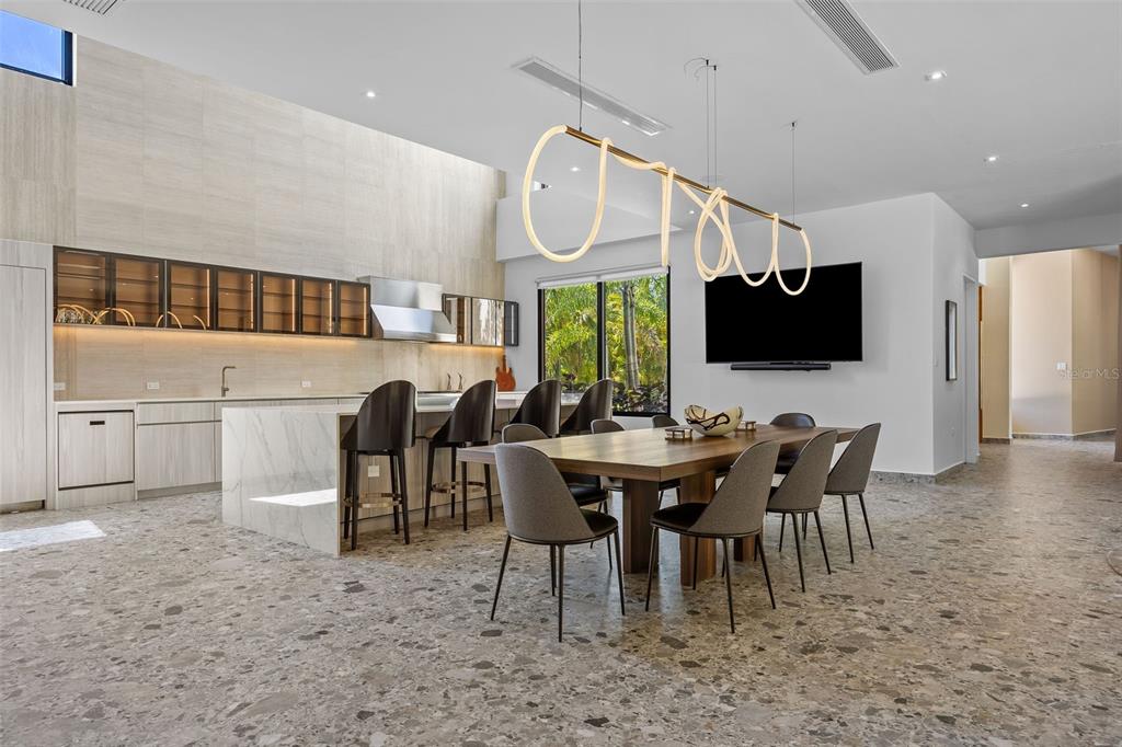 A modern open-concept kitchen and dining area features a marble island, terrazzo flooring, and pendant lighting — 904 VILLA DORADO ESTATES, DORADO, PR