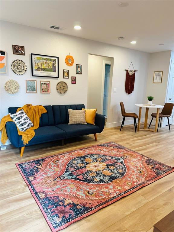 A living room features a blue sofa, a patterned rug, and a small dining area — 6602 S FAUL STREET, TAMPA, FL