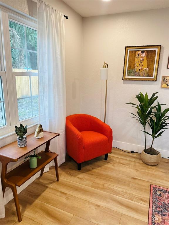 A corner of a room features a bright orange armchair, a wooden console table, and a floor lamp — 6602 S FAUL STREET, TAMPA, FL