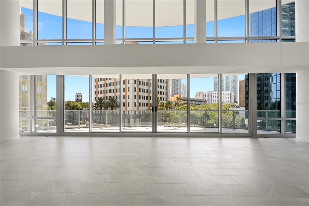 A modern kitchen features white glossy cabinets, wood-toned lower cabinets, a large island, and stainless appliances — 400 CENTRAL AVENUE UNIT 407, ST PETERSBURG, FL