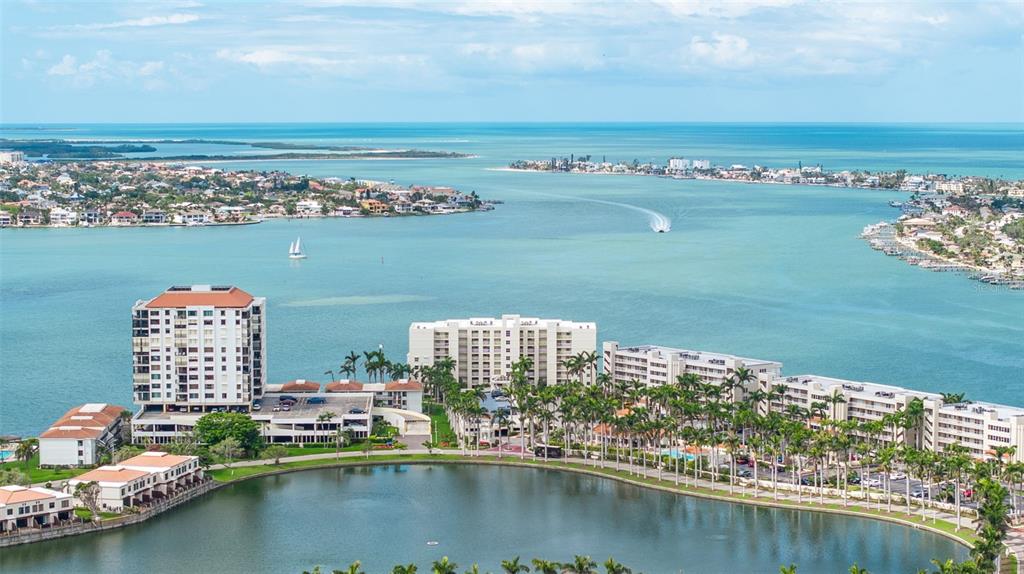 An aerial view shows waterfront apartment buildings situated along a lake and a large bay — 6105 BAHIA DEL MAR CIRCLE UNIT 683, ST PETERSBURG, FL