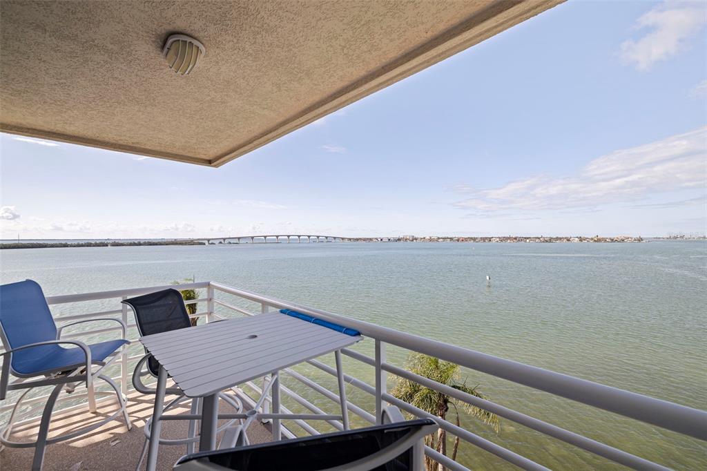 A balcony with patio furniture overlooks a large body of water and a distant bridge — 6105 BAHIA DEL MAR CIRCLE UNIT 683, ST PETERSBURG, FL