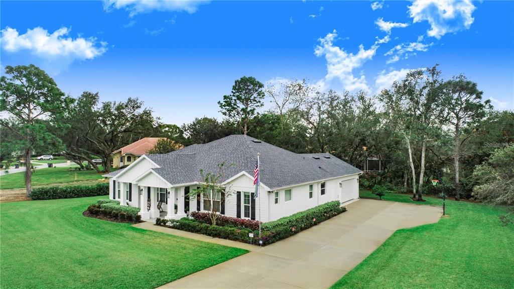 An aerial view of a white single-story house with a gray roof and concrete driveway — 2997 SEQUOYAH DRIVE, HAINES CITY, FL