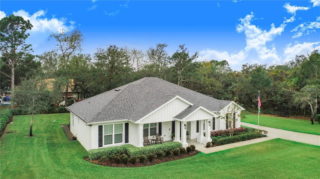 A white single-story house with a gray shingled roof sits on a grassy lot — 2997 SEQUOYAH DRIVE, HAINES CITY, FL