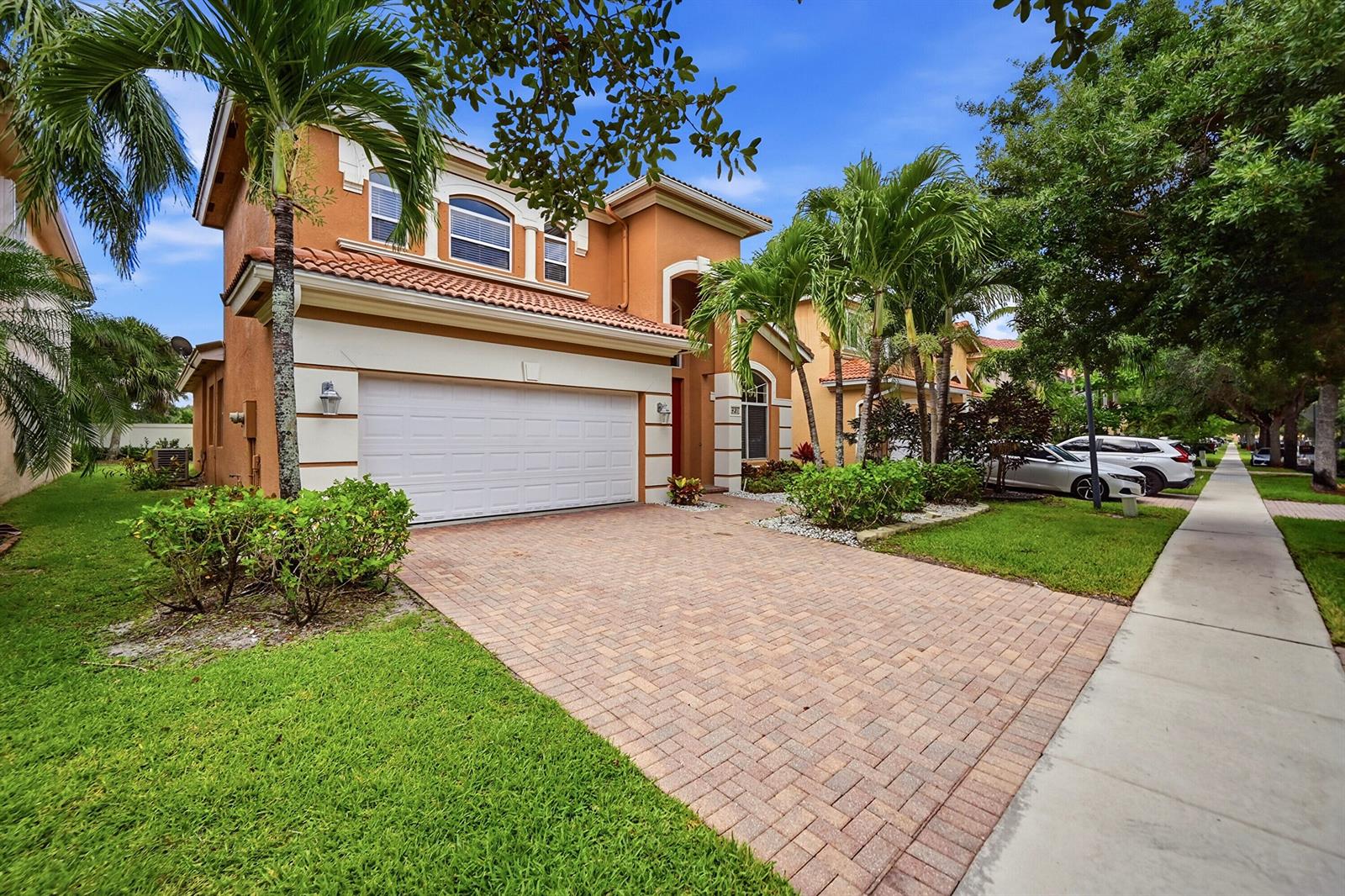 A two-story house with a brick paver driveway, two-car garage, and palm trees — 421 Gazetta Way, West Palm Beach FL 33413, WEST PALM BEACH, FL