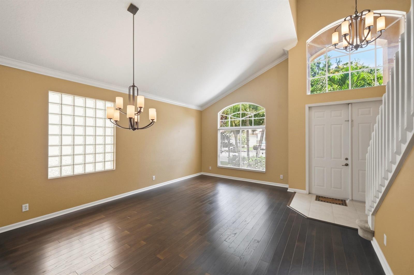 An empty room with dark wood floors, a glass block window, and a vaulted ceiling — 421 Gazetta Way, West Palm Beach FL 33413, WEST PALM BEACH, FL
