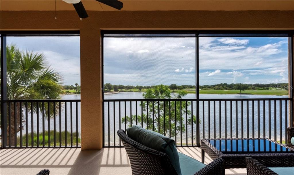 A screened-in patio overlooks a lake and a golf course — 23479 AWABUKI DRIVE UNIT 202, VENICE, FL