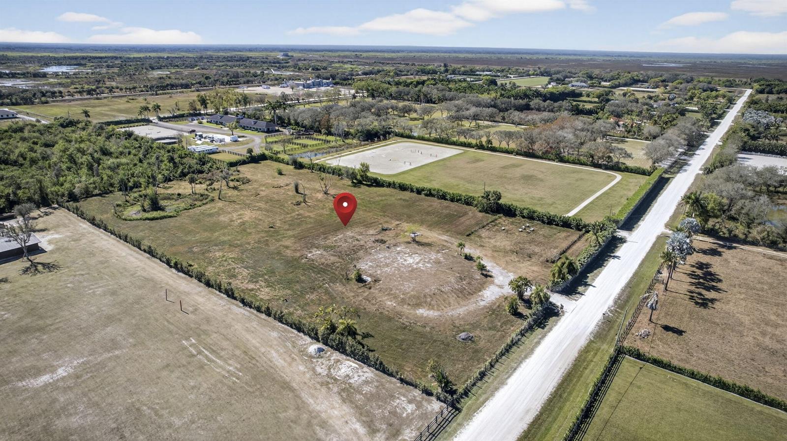 An aerial view shows a vacant, fenced plot of land with a red location pin — 16296 Deer Path Lane, Wellington FL 33470, WELLINGTON, FL