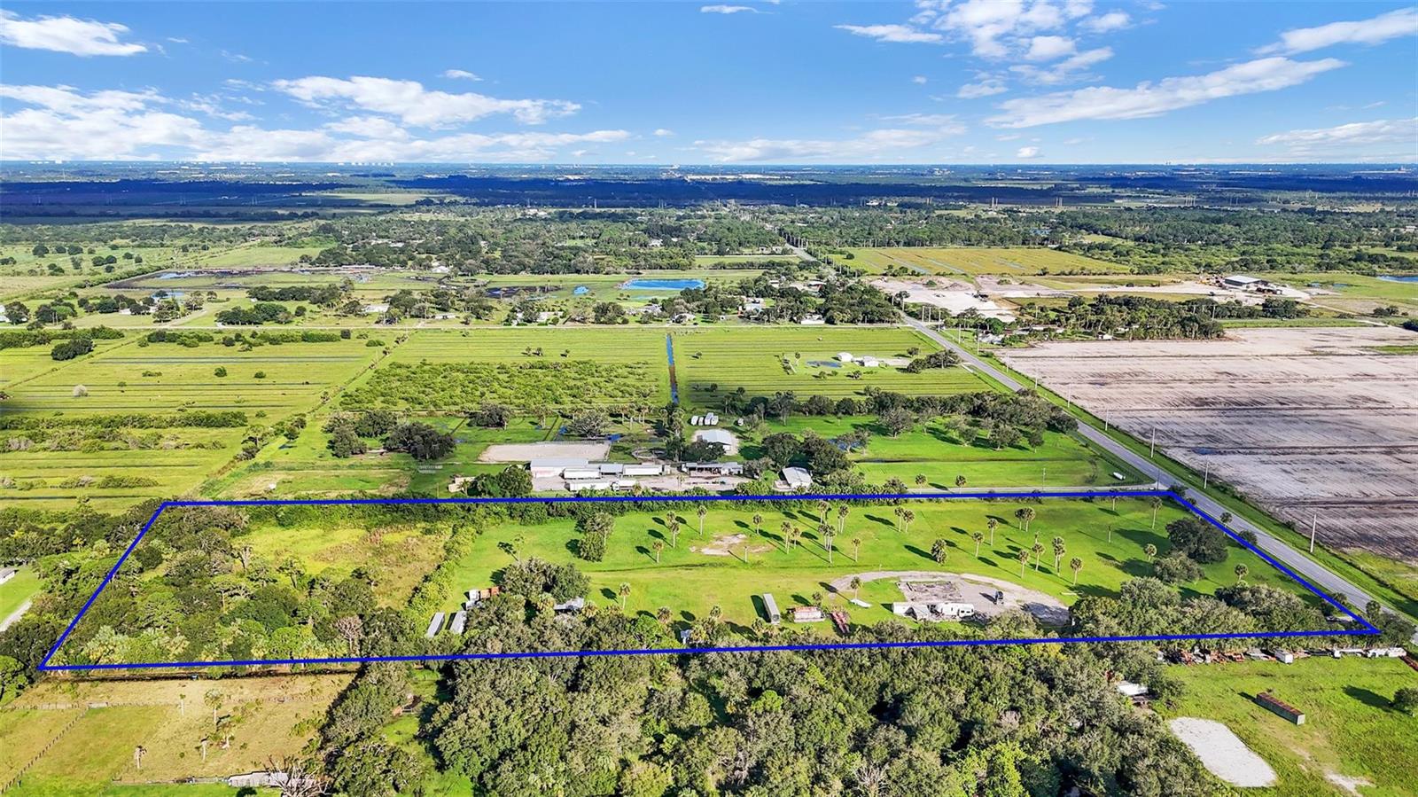 An aerial view shows a rectangular plot of land outlined in blue with scattered trees — 15150 Orange Avenue, Fort Pierce FL 34945, FORT PIERCE, FL