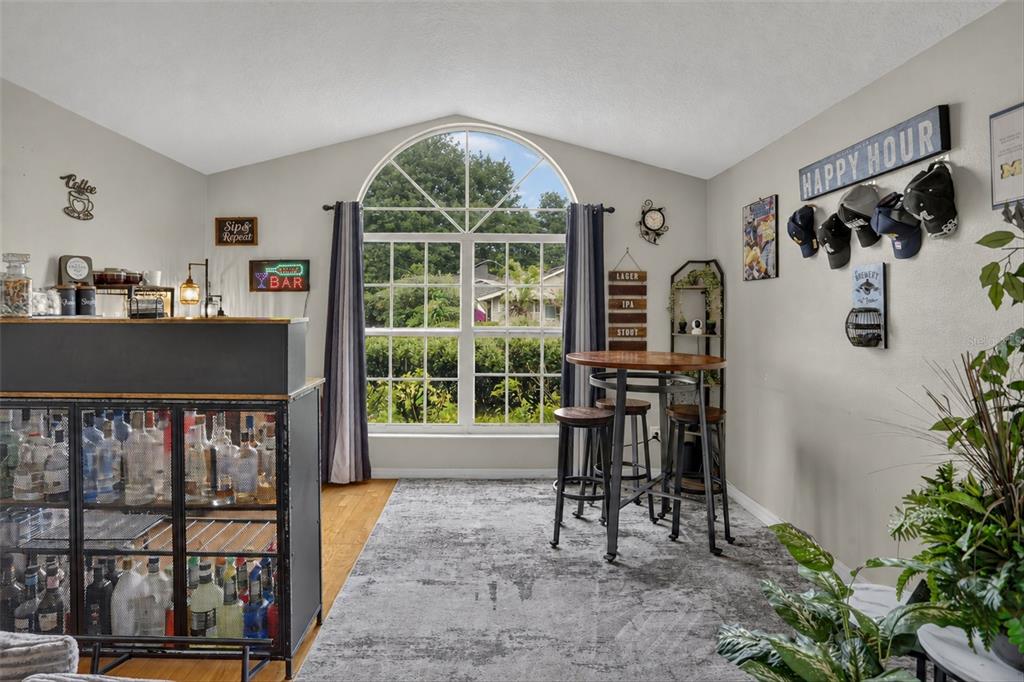 A home bar area features a glass-front liquor cabinet, a high-top table, and a large window — 19654 GLEN ELM WAY, ORLANDO, FL
