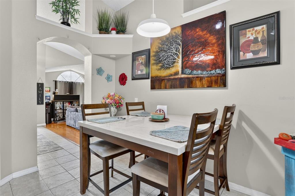 A dining area features a table with four chairs, wall art, and a tiled floor — 19654 GLEN ELM WAY, ORLANDO, FL
