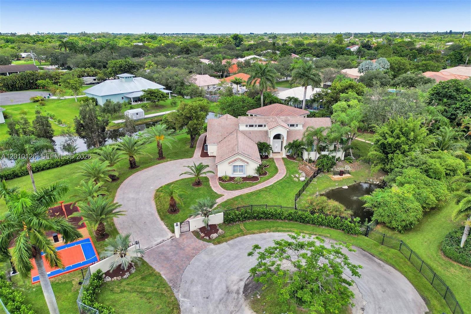 An aerial view shows a house with a circular driveway, a pond, and a playground — 16301 SW 62nd St, Southwest Ranches FL 33331, SOUTHWEST RANCHES, FL