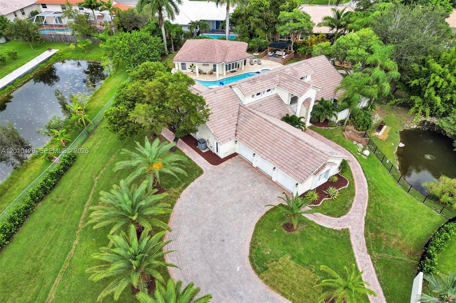 An aerial view shows a house with a tiled roof, pool, and surrounding ponds — 16301 SW 62nd St, Southwest Ranches FL 33331, SOUTHWEST RANCHES, FL