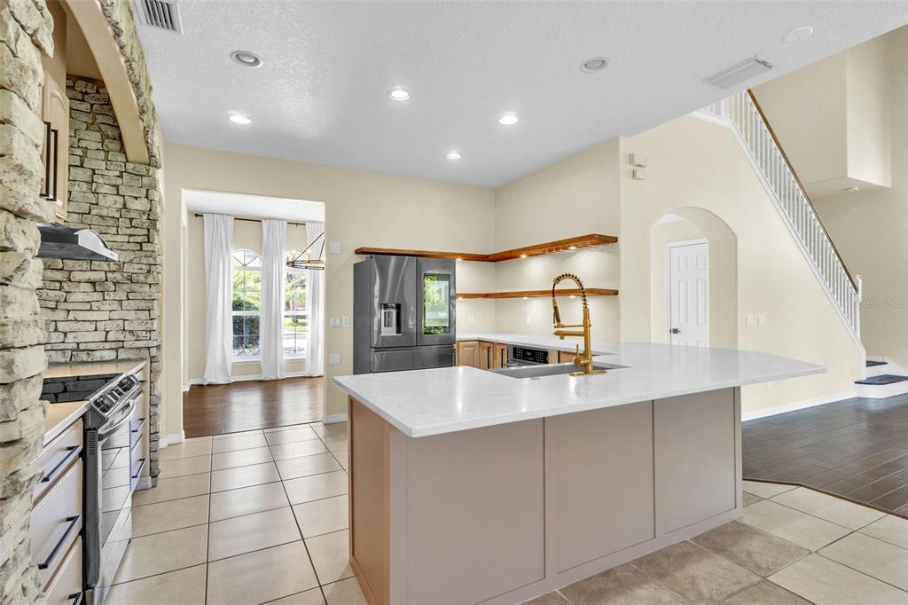 A kitchen features a stone-accented stove area, a central island, and open wooden shelving — 4617 PATRICIA ANN COURT, ORLANDO, FL