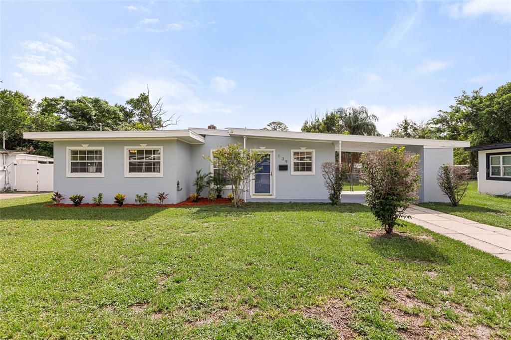 A single-story light blue house with a flat roof and an attached carport — 139 S ALDER DRIVE, ORLANDO, FL