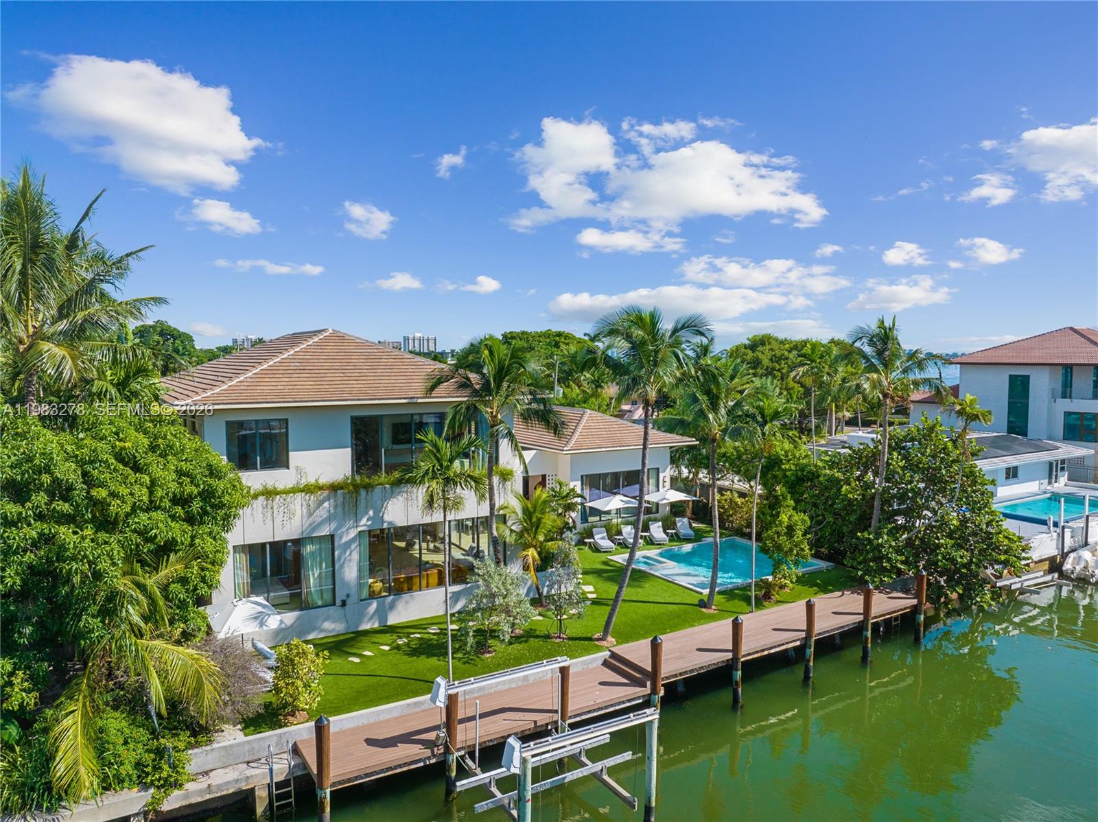 An aerial view of a waterfront house with a pool, dock, and palm trees — 1200 NE 87th St, Miami FL 33138, MIAMI, FL