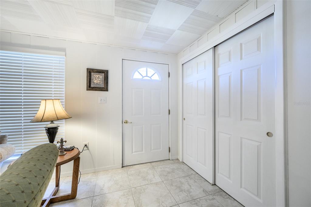 An entryway features white walls, a tiled floor, a front door, and sliding closet doors — 330 HARVEY STREET, PUNTA GORDA, FL