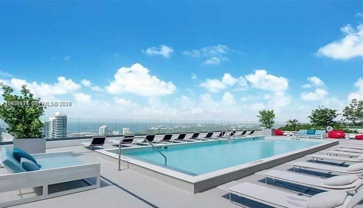 This is a rendering of a rooftop swimming pool with lounge chairs overlooking a city — 45 SW 9th St # 3906, Miami FL 33130, MIAMI, FL