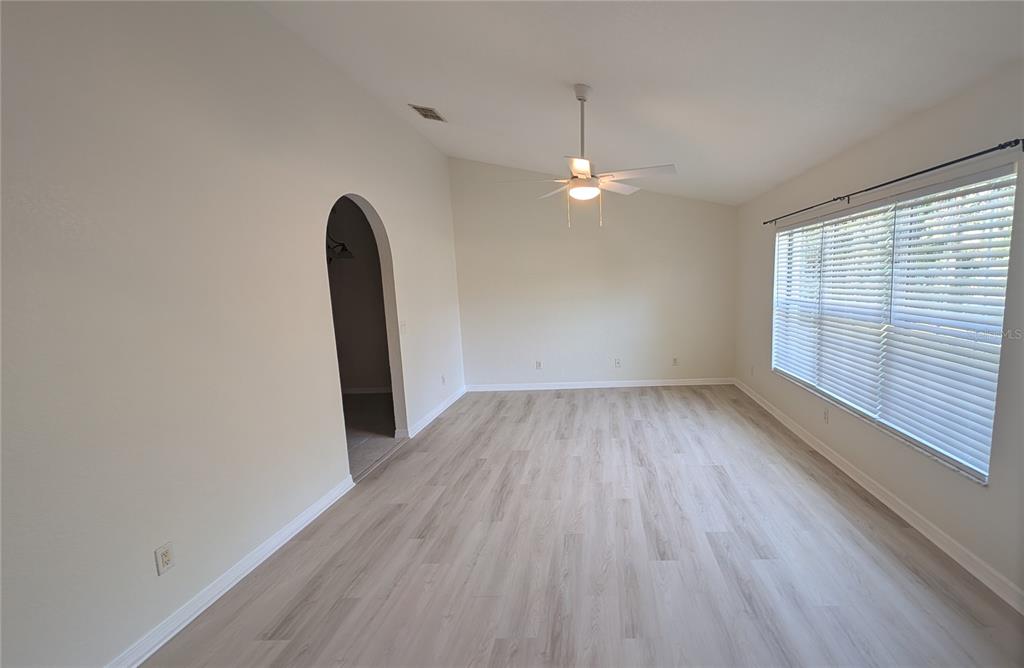 An empty room with light wood-look flooring, a vaulted ceiling, a ceiling fan, and blinds — 4023 N EAGLE NEST POINT, CRYSTAL RIVER, FL