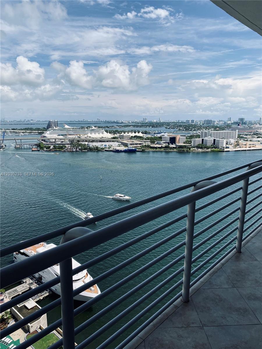 A high-angle view from a balcony overlooking a harbor with boats and a cruise ship — 335 S BISCAYNE BLVD # 2908, Miami FL 33131, MIAMI, FL