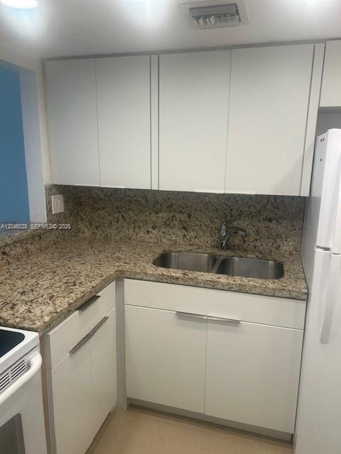 A kitchen features white flat-panel cabinets, granite countertops, and a double-basin stainless steel sink — 10395 N Kendall Dr # V4, Miami FL 33176, MIAMI, FL