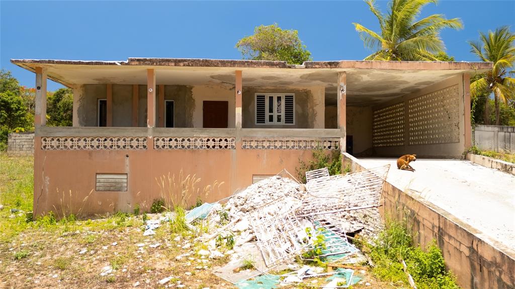 A single-story house with a flat roof, open porch, and debris in the front yard — M-4 MONTE SANTO, VIEQUES, PR