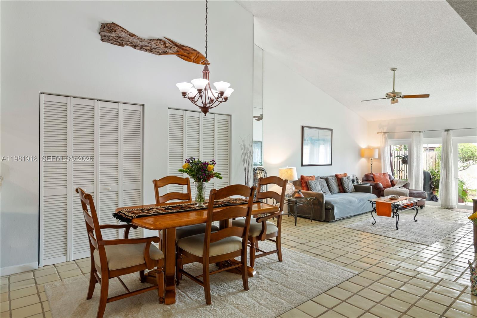 A dining area with a wooden table and chairs sits adjacent to a living room — 19994 NE 5th Ct # 3C, Miami FL 33179, MIAMI, FL