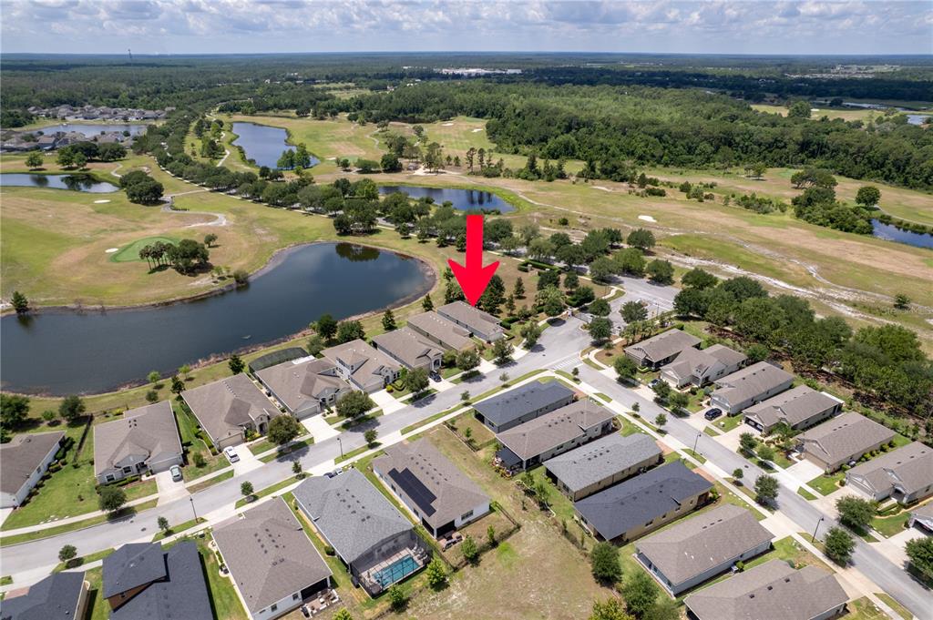 An aerial view shows a suburban neighborhood with houses, a golf course, and ponds — 3300 SAGEBRUSH STREET, HARMONY, FL