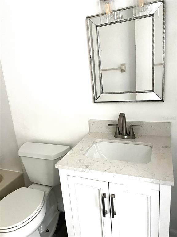 A bathroom features a white vanity with a stone countertop, a sink, and a mirror — 4440 S LAKE ORLANDO PARKWAY UNIT 6-4, ORLANDO, FL