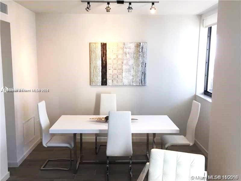 A dining room features a white table, four white chairs, and abstract wall art — 999 SW 1st Ave # 2115, Miami FL 33130, MIAMI, FL