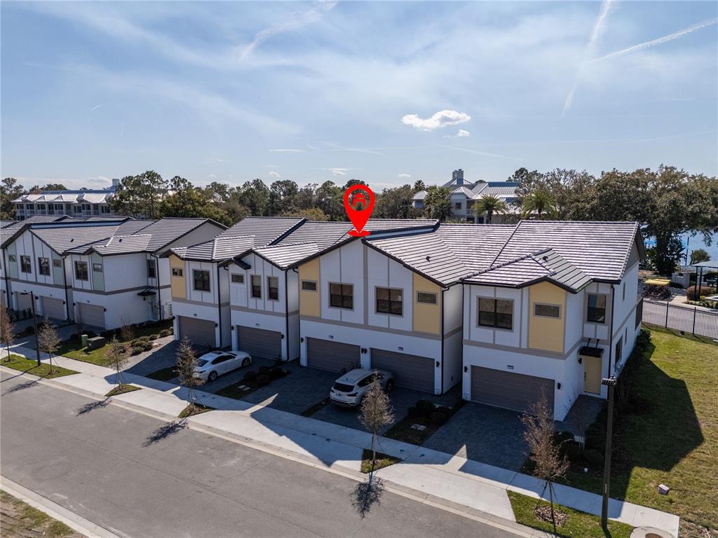 An aerial view shows a row of modern townhomes with attached garages and tiled roofs — 10580 EBB TIDE LANE, ORLANDO, FL